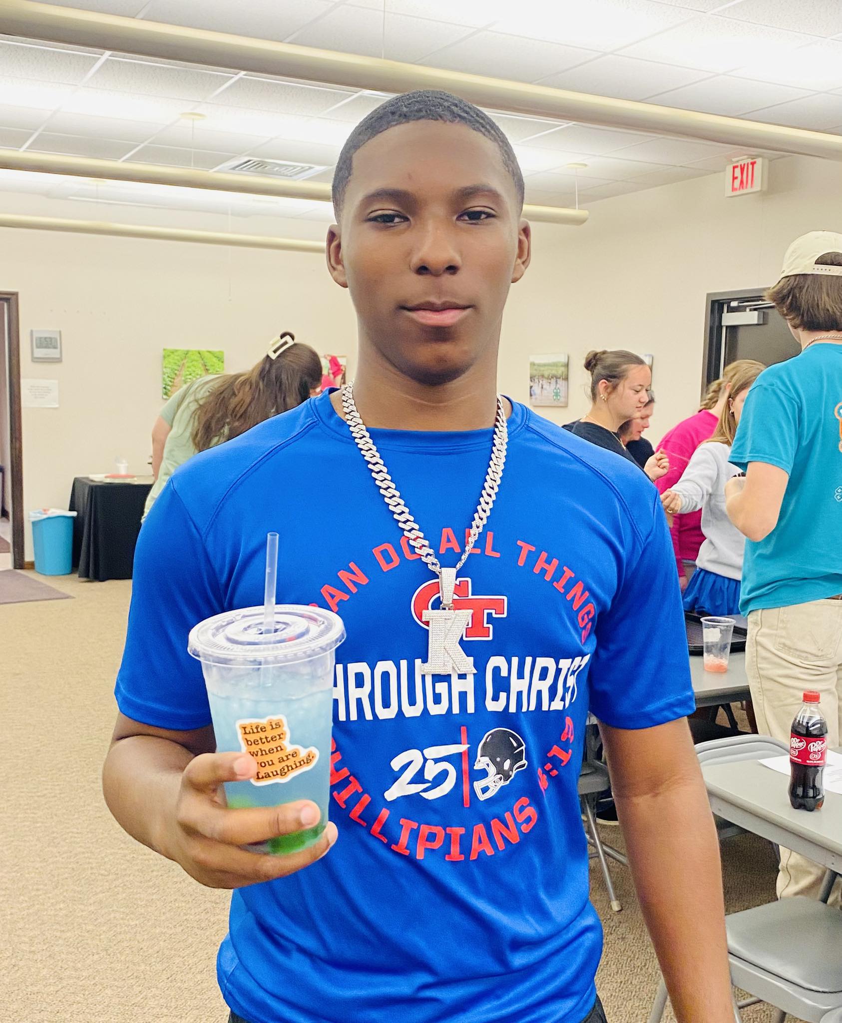 A boy holding a drink.